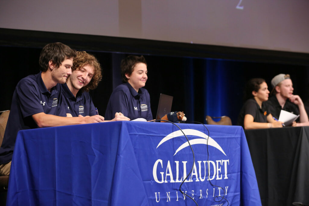 Gallaudet college bowl players are writing their answer.
