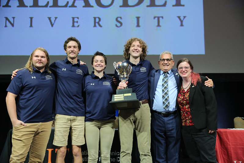 Gallaudet University college bowl team smiling with the trophy. From L to R: Trevor, Donovan, Thalia, Jonathan, Bob, and Meredith.